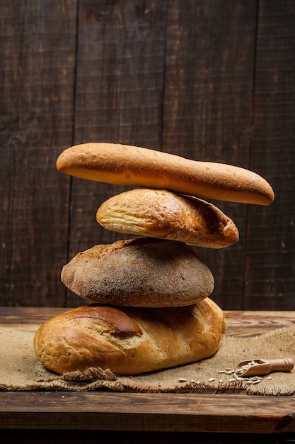 Photo miches de pain frais avec du blé et du gluten sur une table en bois