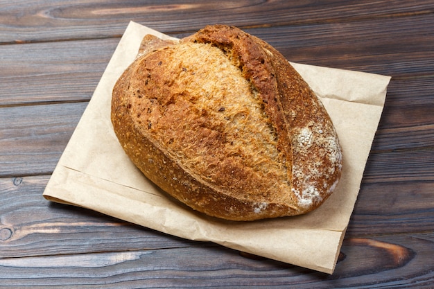 Miches de pain frais sur une table en bois avec un sac en papier. Vue de dessus