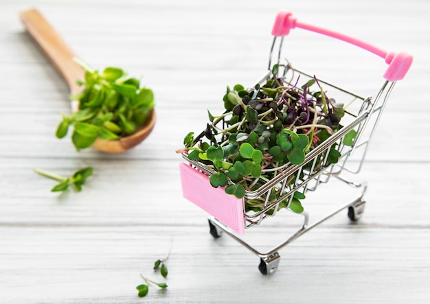 Micro verts dans le panier sur fond de bois. Différents types de microgreens à vendre. Concept d'alimentation saine