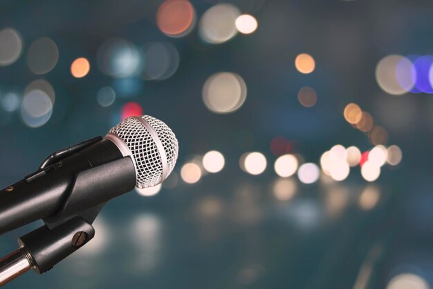 Microphone sur le bokeh flou de la lumière et de l'arrière-plan de la salle Concept de musique et de chant