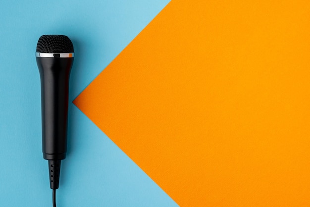 Photo microphone à câble sur le côté gauche de la conception de fond turquoise et orange coloré au-dessus de l'espace de copie