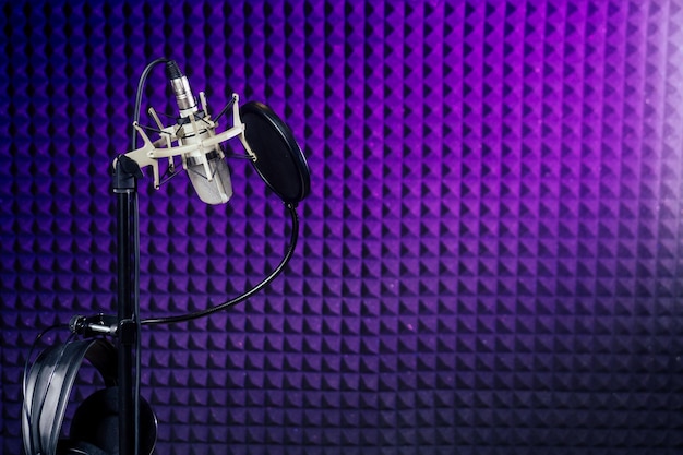 Microphone et casque dans un mur insonorisé de studio d'enregistrement