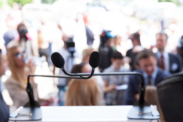 Photo microphone en focus lors d'un événement de presse ou public, les participants floués en arrière-plan