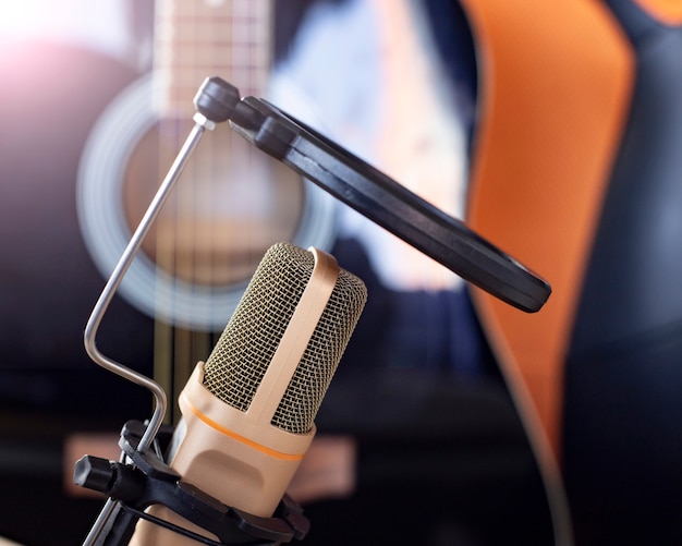 Un microphone et une guitare sur un bureau, étude, télétravail, artistes