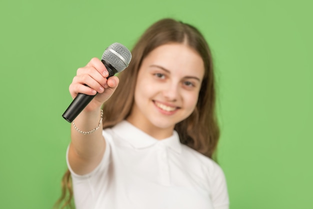 Microphone à la main d'un enfant heureux, mise au point sélective, musique