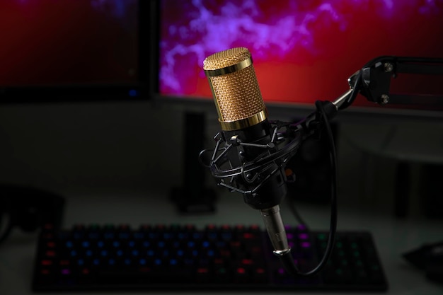 Microphone professionnel avec station de travail gamer en arrière-plan et casque