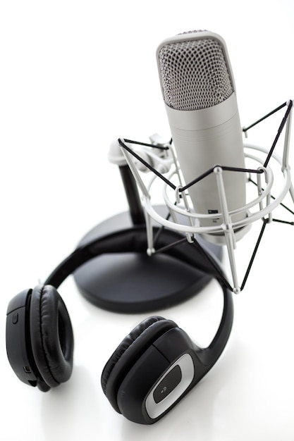 Microphone de studio pour l'enregistrement de podcasts avec casque sur fond blanc.