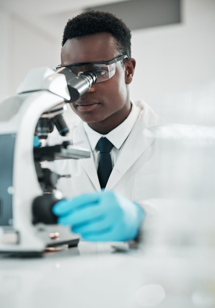 Photo microscope homme noir et analyse avec recherche médicale et expérience pour test de vaccin ou échantillon scientifique ou chercheur africain avec équipement de laboratoire pathologie ou biotechnologie avec guérison