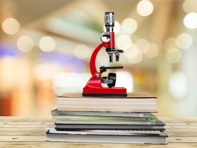 Microscope médical et livres sur table en bois