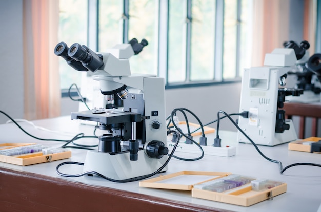 Microscope avec microplaque sur table blanche en laboratoire pour la recherche et l&#39;apprentissage