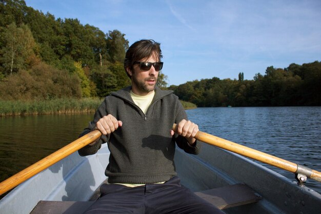 Mid adult man naviguant dans le lac contre le ciel