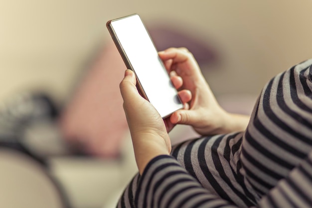 Midsection d'une femme enceinte utilisant un téléphone portable à la maison