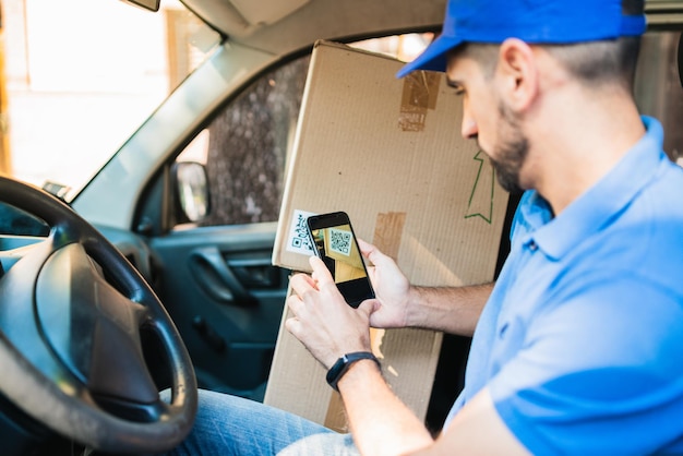 Midsection d'un homme utilisant un téléphone portable dans une voiture