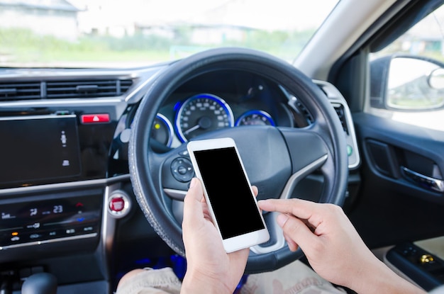 Midsection d'un homme utilisant un téléphone portable dans une voiture