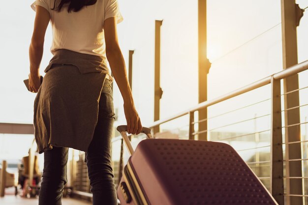 Photo midsection d'une jeune femme tenant des bagages à l'aéroport