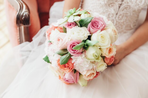 Midsection de la mariée portant une robe de mariée tout en tenant un bouquet
