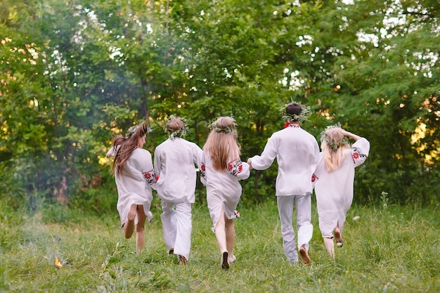 Midsummer. Les gens qui courent dans la nature en vêtements slaves.