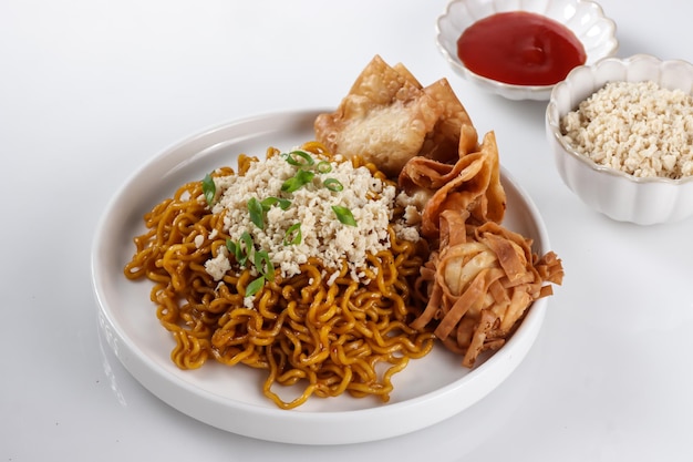 Mie Goreng ala Mie Gacoan est une garniture de nouilles frites maison avec du poulet râpé et une boulette frite.