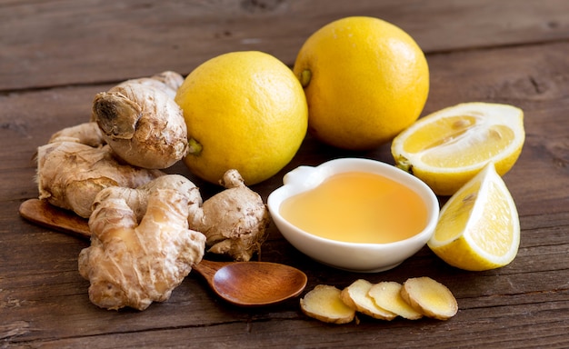 Miel, citron et gingembre sur une table en bois se bouchent