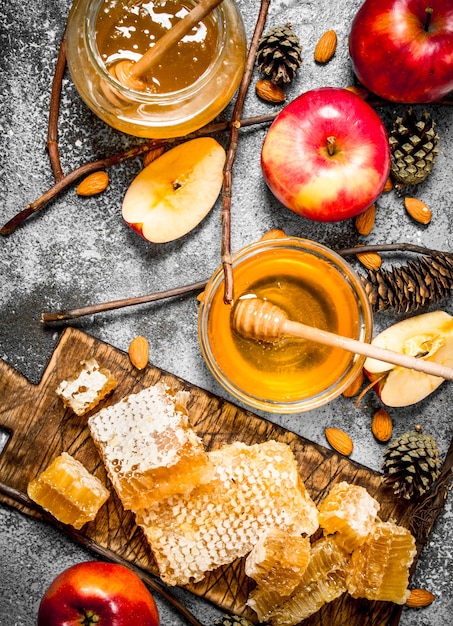 Miel dans des bols en verre avec des pommes et des noix