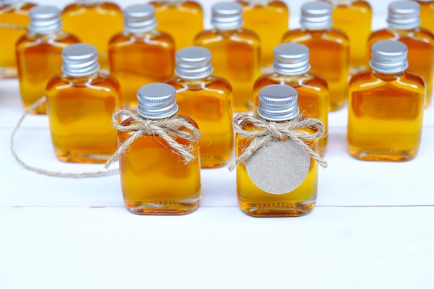 Miel dans les bouteilles en verre pour cadeau de mariage avec étiquette brune.