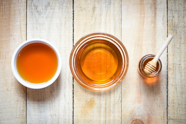 Miel dans un pot avec une cuillère en bois sur un fond en bois tasse de miel