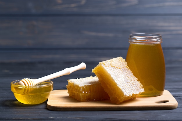 Miel doux dans le bocal en verre avec nid d'abeille