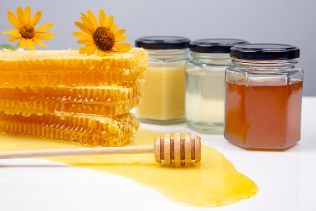 Miel de fleurs fraîches dans un bol en bois, une cuillère et un nid d'abeilles. aliments vitaminés pour la santé et la vie