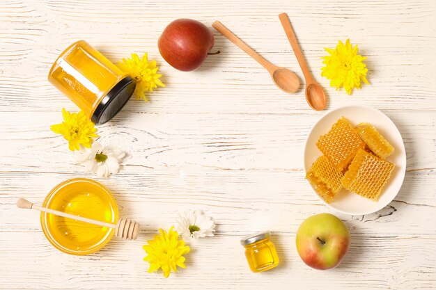 Miel, fleurs et pommes sur fond de bois blanc, espace copie