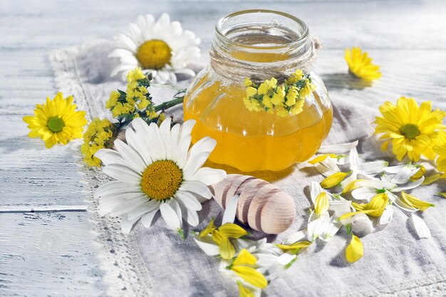 Miel et fleurs sur serviette sur fond de bois