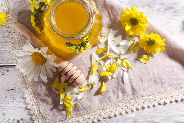 Miel et fleurs sur serviette sur fond de bois