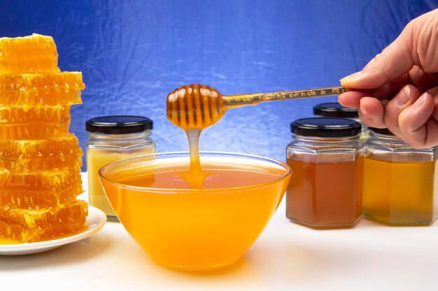 Miel floral frais dégoulinant d'une cuillère dans une assiette d'aliments naturels en vitamines biologiques