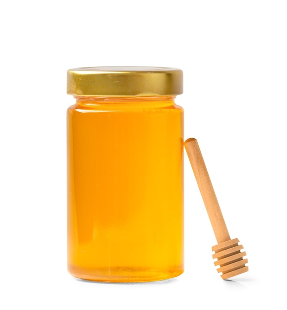Miel frais dans un bocal avec une louche en bois sur un fond blanc isolé