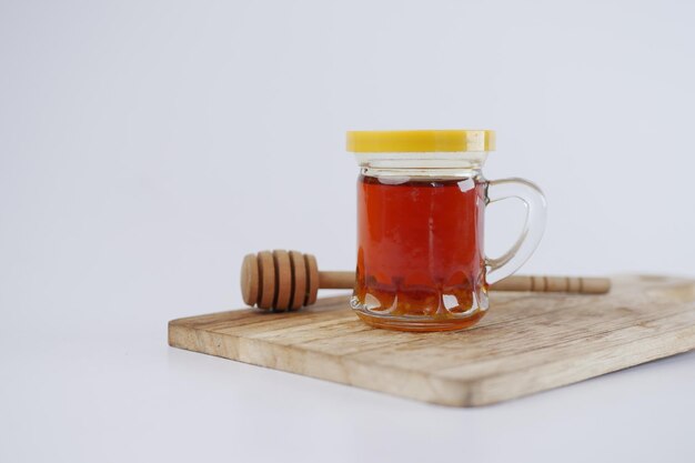 Miel frais dans un bocal en verre isolé sur blanc