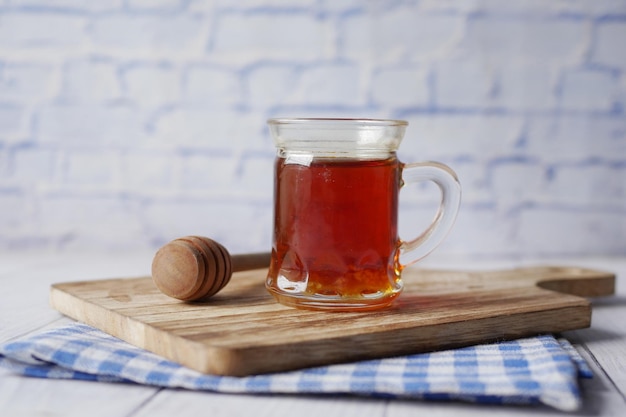 Miel frais dans un pot et une cuillère en bois sur la table