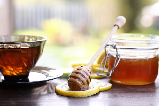 Un miel frais parfumé avec une tasse de thé noir