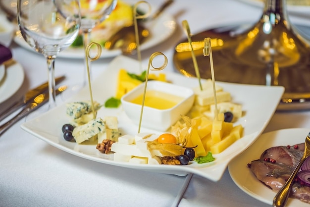 Miel et fromages sur une assiette blanche, nourriture.