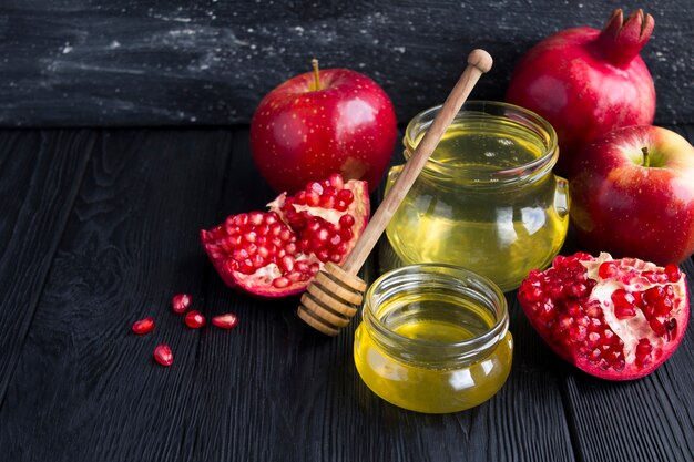 Miel, grenade et pommes rouges sur fond noir