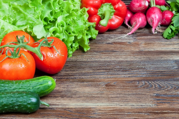 Miel de légumes biologiques frais sur table en bois brun. laitue, tomate, concombre, radis. Fond avec espace copie