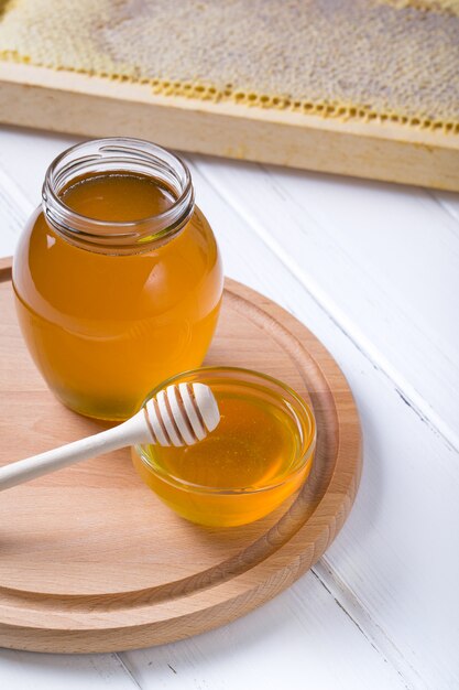 Miel avec une louche en bois sur table en bois