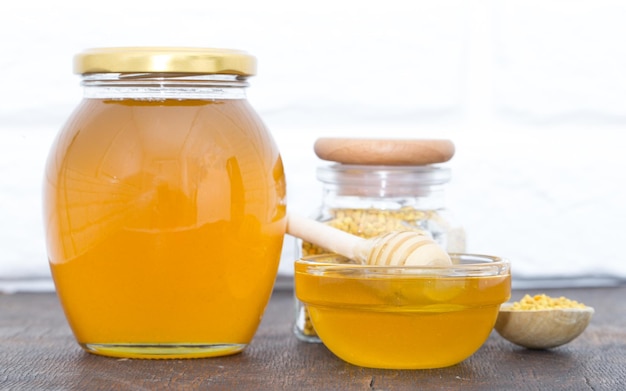 Miel avec louche à miel en bois sur table en bois