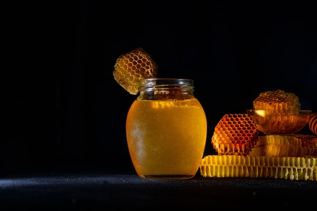 Miel avec nid d'abeille sur table noire