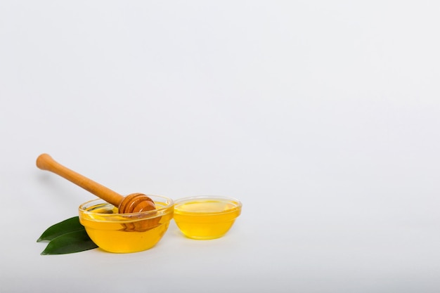 Miel en pot avec feuilles et louche de miel sur la vue de dessus de fond coloré avec copie de texte