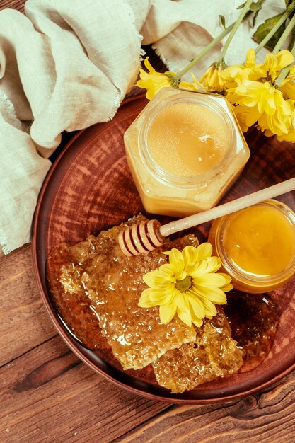 Miel en pot avec une louche de miel sur fond en bois vintage