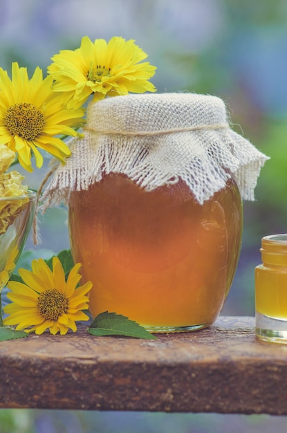 Miel en pot avec une louche à miel sur une table en bois rustique. Miel doux dans le peigne. Concept d'aliments sains. Produits de miel par des ingrédients biologiques.