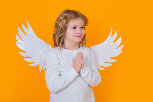 Mignon ange enfant studio portrait ange enfant avec des ailes d'anges fond isolé