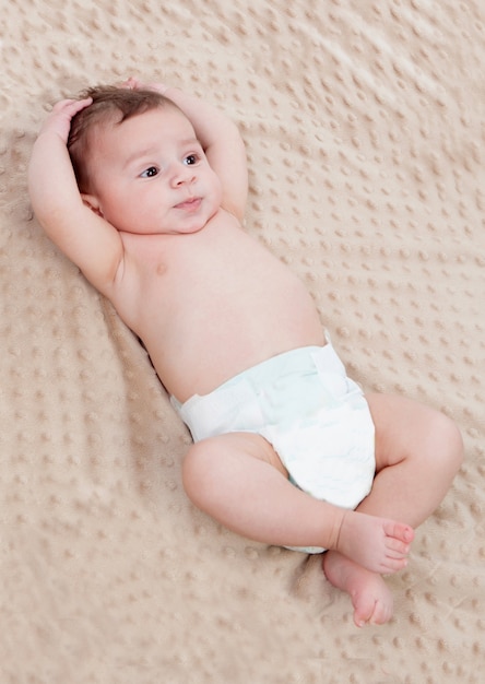 Mignon bébé sur une couverture brune surpris