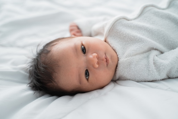 Mignon bébé nouveau-né allongé sur le lit