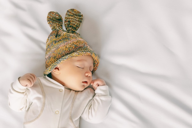 Mignon bébé nouveau-né au chapeau avec des oreilles de lapin