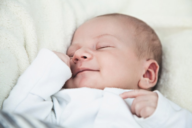 Mignon bébé nouveau-né souriant endormi